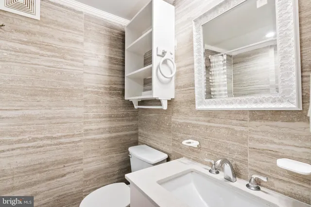 a bathroom with a sink mirror and toilet