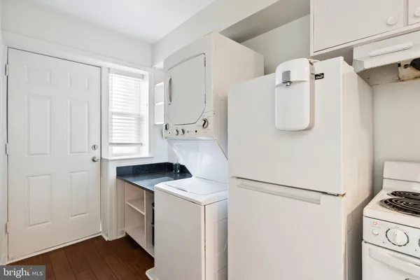 a white refrigerator freezer and a wooden floor