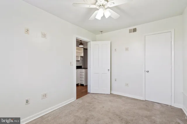an empty room with closet and a chandelier fan