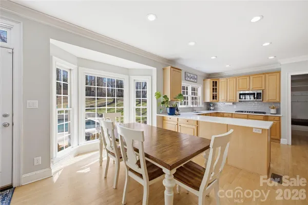 a dining area with stainless steel appliances granite countertop a dining table chairs and granite counter tops