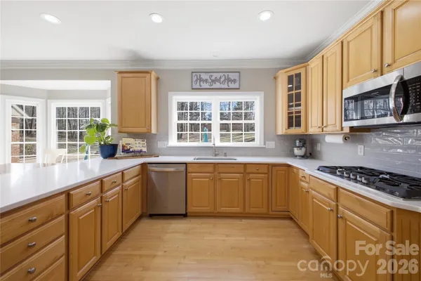 a large kitchen with stainless steel appliances granite countertop a stove a sink and a granite counter tops