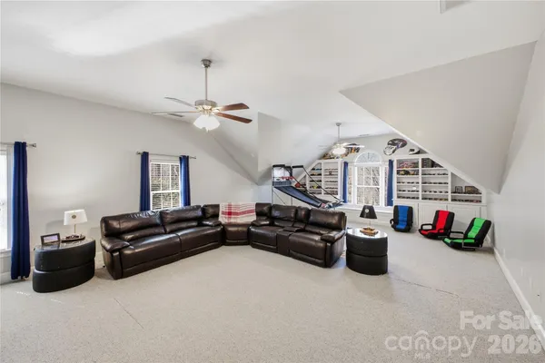 a living room with furniture a flat screen tv and a chandelier
