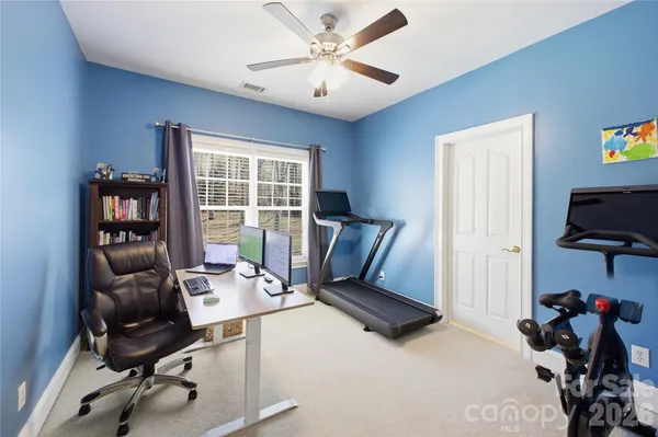 a view of a workspace with furniture and a window