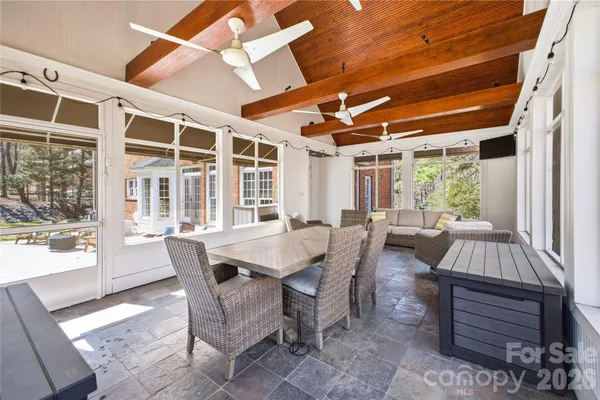 a dining room with furniture a chandelier and wooden floor
