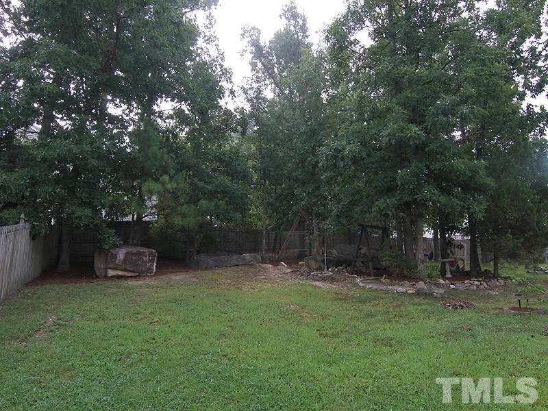 6844 Coventry Ridge Road Raleigh, NC 27616 - Photo 12 of 13 a backyard of a house with lots of green space and fountain