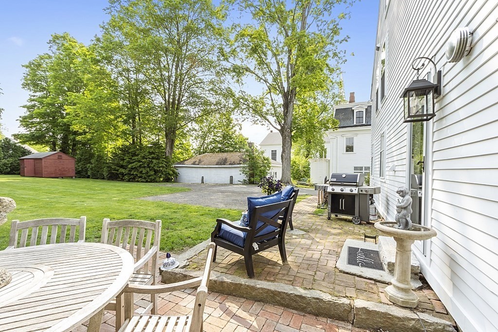 228 Main Street Groton, MA 01450 - Photo 34 of 35 a view of a patio with table and chairs and potted plants with wooden floor and fence
