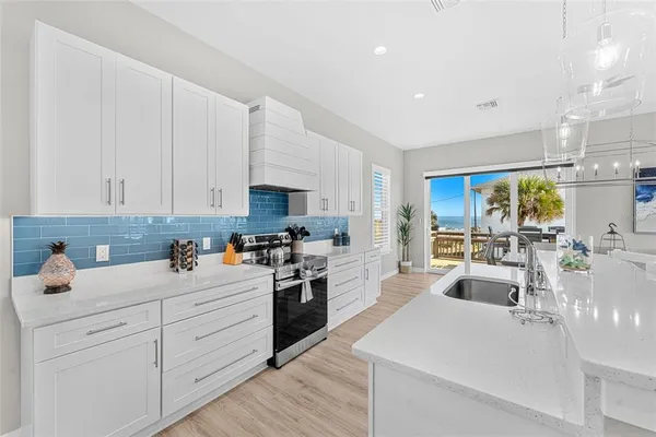 a kitchen with stainless steel appliances a sink a stove top oven a counter space and cabinets