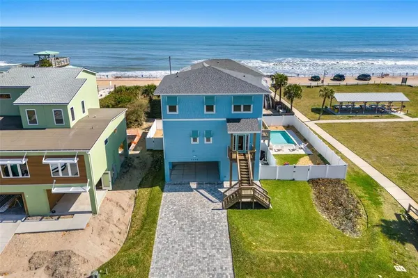 an aerial view of a house with swimming pool and ocean view