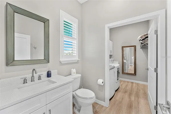 a view of washer and dryer with bathroom in the background