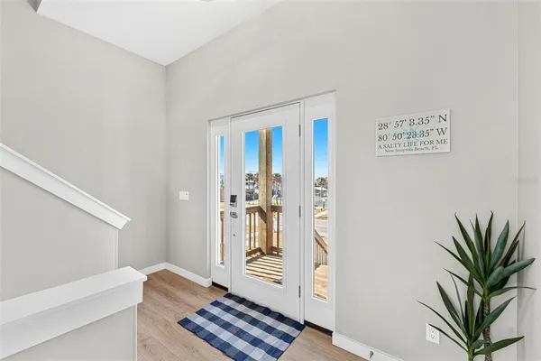 a view of a hallway with wooden floor and a livingroom