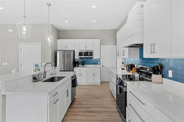 a kitchen with white cabinets and white appliances