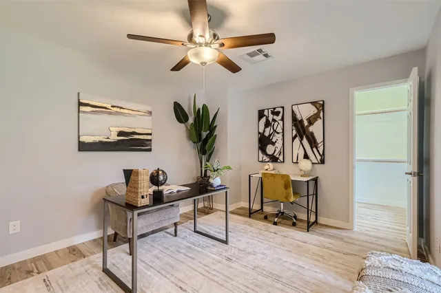 a view of a workspace with furniture and wooden floor