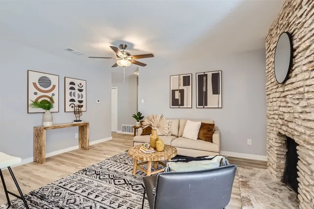 a living room with furniture a fireplace and a floor to ceiling window