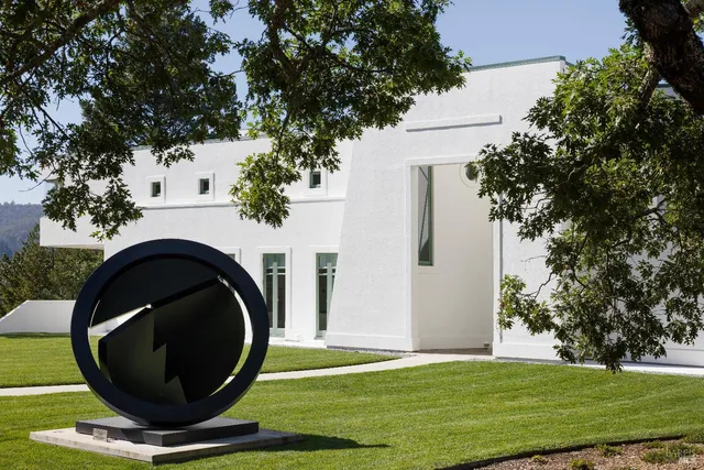 a living room with furniture a large window and a potted plant