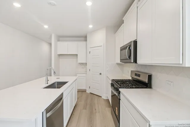 a kitchen that has a sink and a stove in it