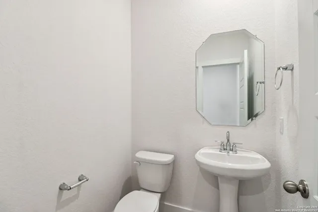 a bathroom with a toilet sink and mirror