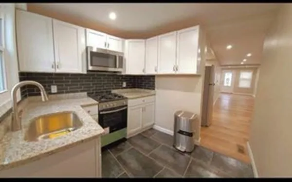 a kitchen with a sink a stove and cabinets