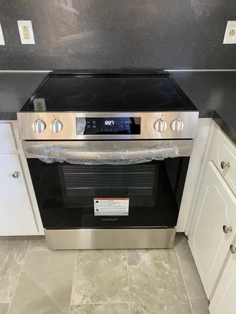 a stove top oven sitting inside of a kitchen