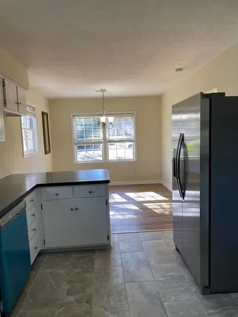 a kitchen with granite countertop a refrigerator and a sink