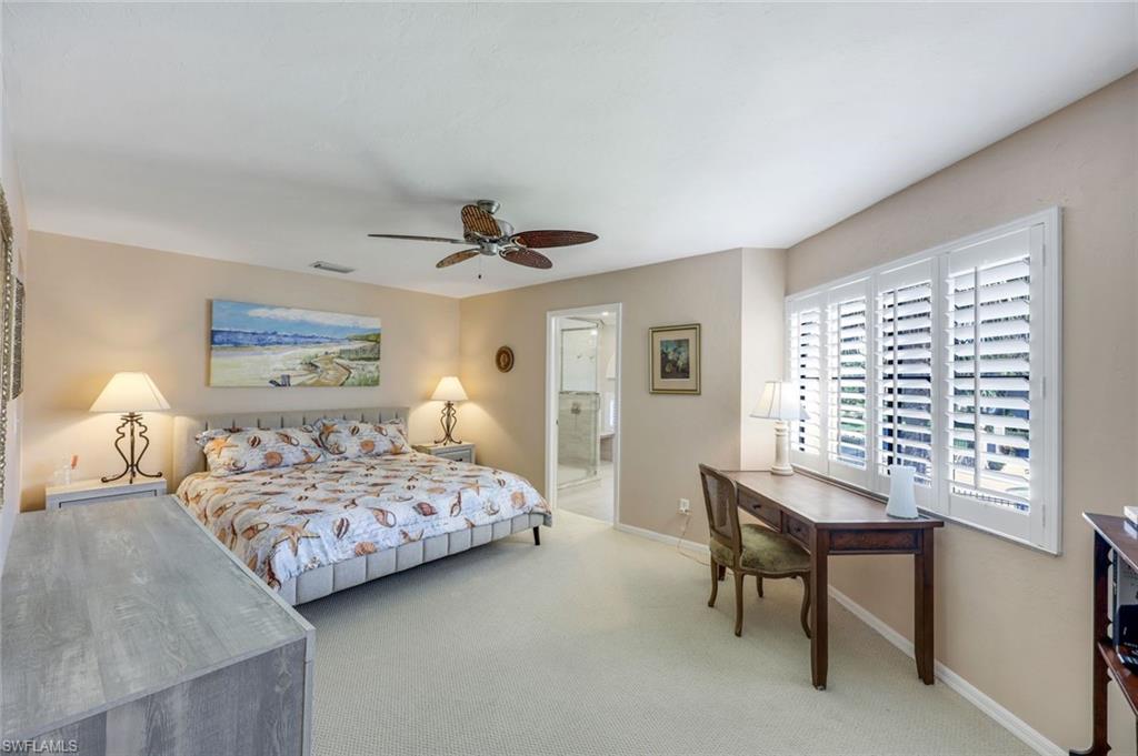 6555 Valen Way, Unit G201 Naples, FL 34108 - Photo 11 of 26 a bedroom with a bed and a table in it