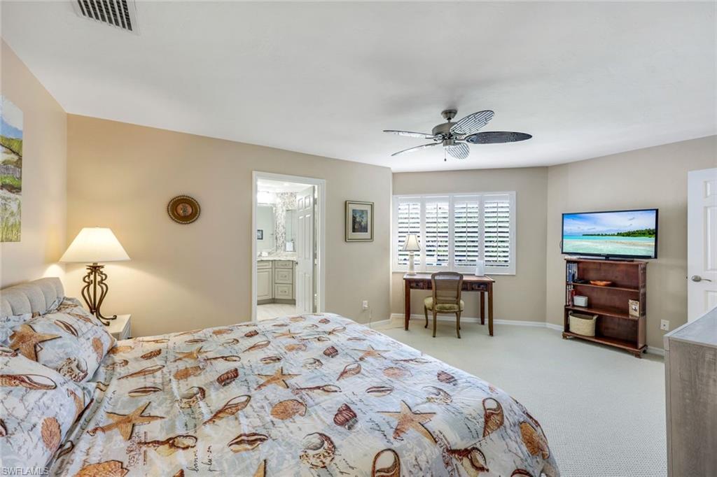 6555 Valen Way, Unit G201 Naples, FL 34108 - Photo 12 of 26 a bedroom with a bed and a table with chair