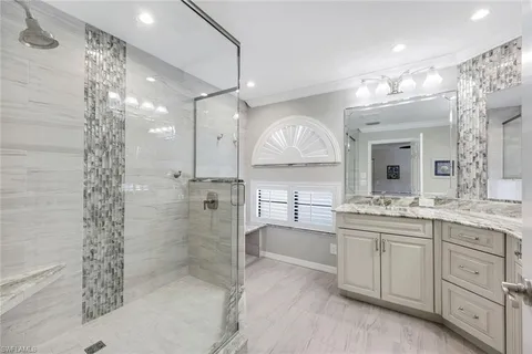 a bathroom with a double vanity sink mirror and shower