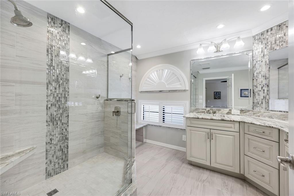 6555 Valen Way, Unit G201 Naples, FL 34108 - Photo 14 of 26 a bathroom with a double vanity sink mirror and shower