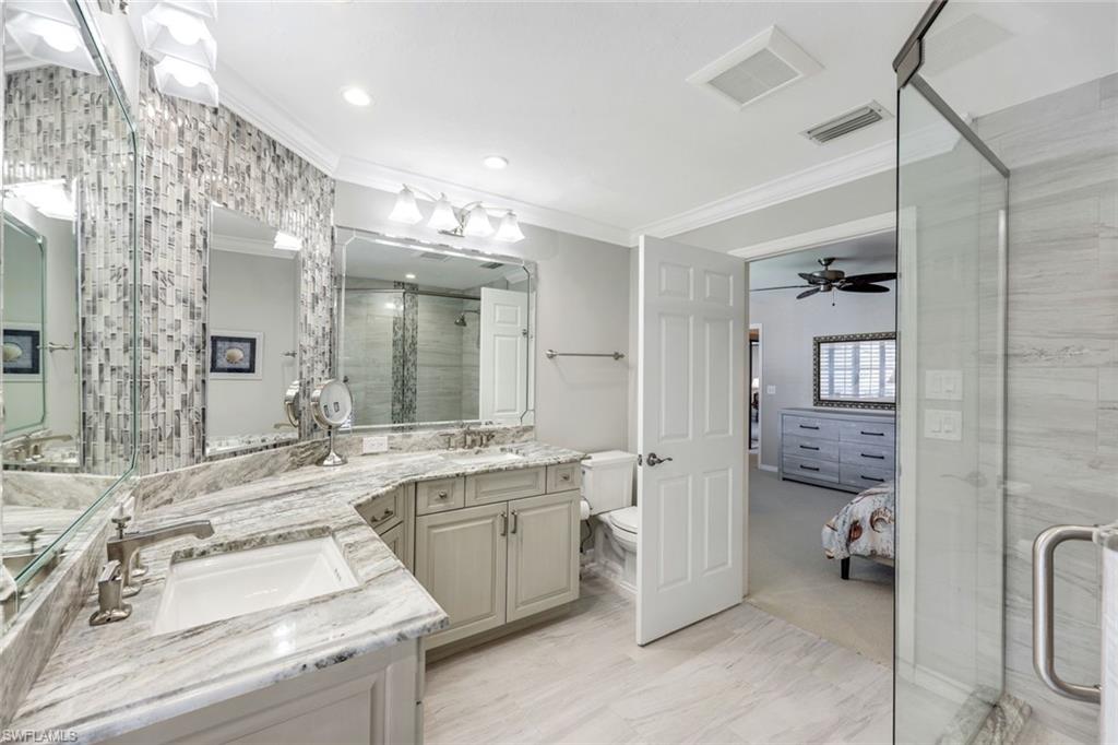 6555 Valen Way, Unit G201 Naples, FL 34108 - Photo 15 of 26 a bathroom with a sink double vanity and a toilet