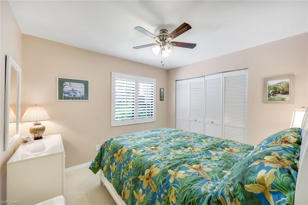 6555 Valen Way, Unit G201 Naples, FL 34108 - Photo 16 of 26 a bedroom with a bed and a window