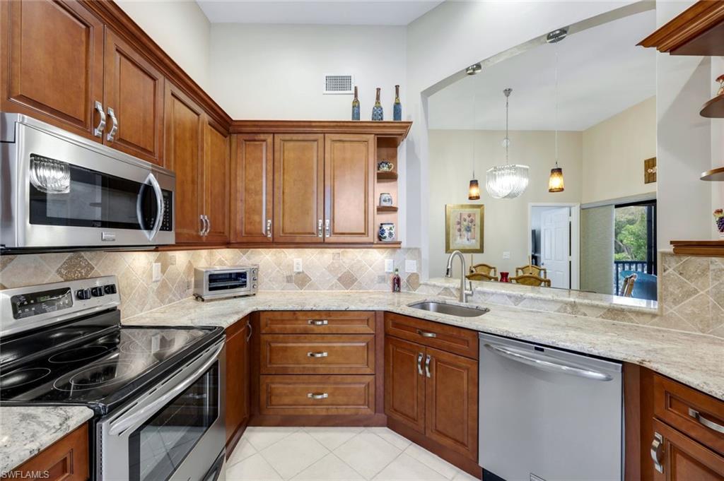 6555 Valen Way, Unit G201 Naples, FL 34108 - Photo 5 of 26 a kitchen with a sink stove and microwave