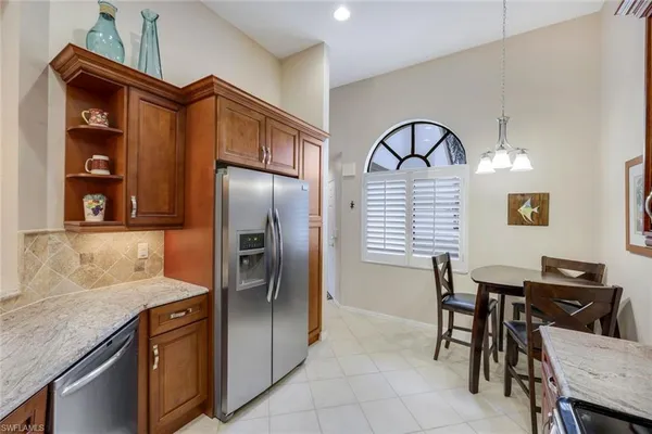 a kitchen with stainless steel appliances granite countertop a refrigerator and a stove top oven