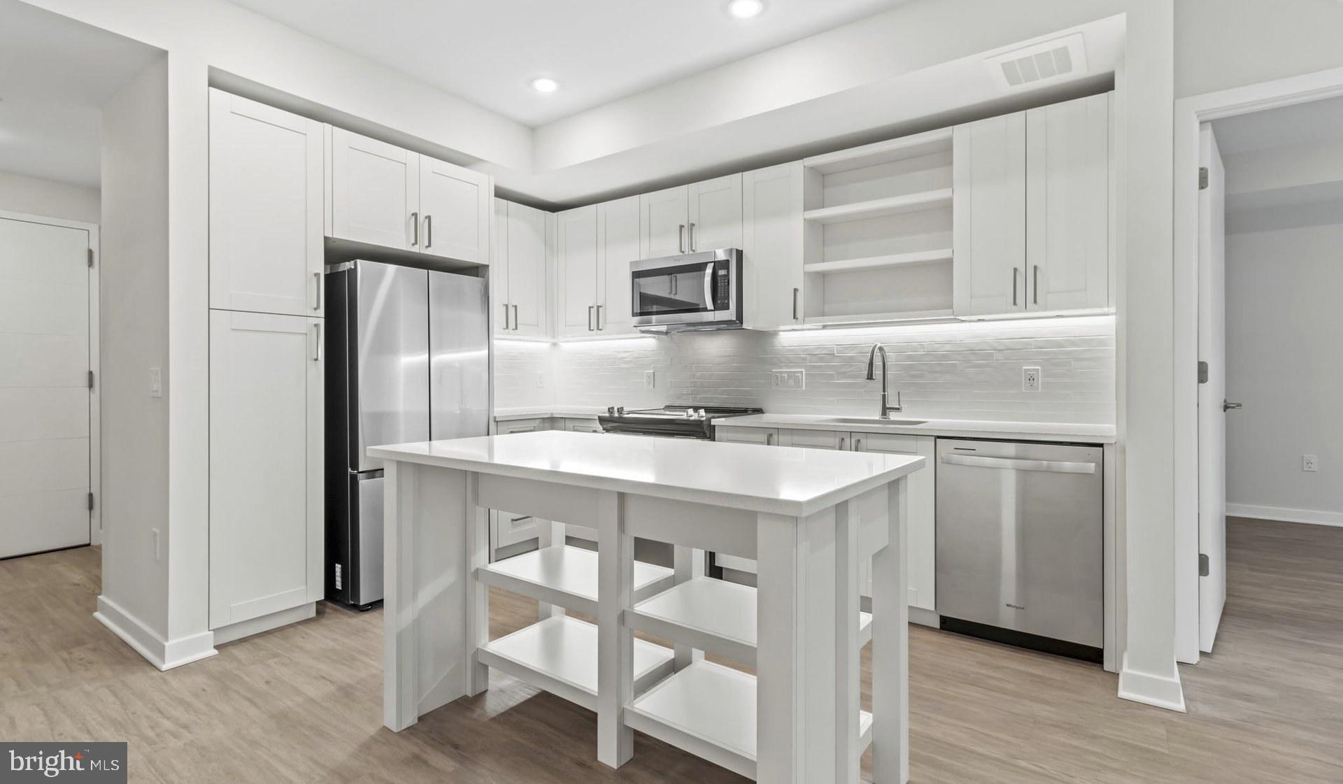 4000 Wisconsin Avenue Northwest, Unit 4K236 Washington, DC 20016 - Photo 19 of 54 a kitchen with kitchen island a sink appliances and cabinets