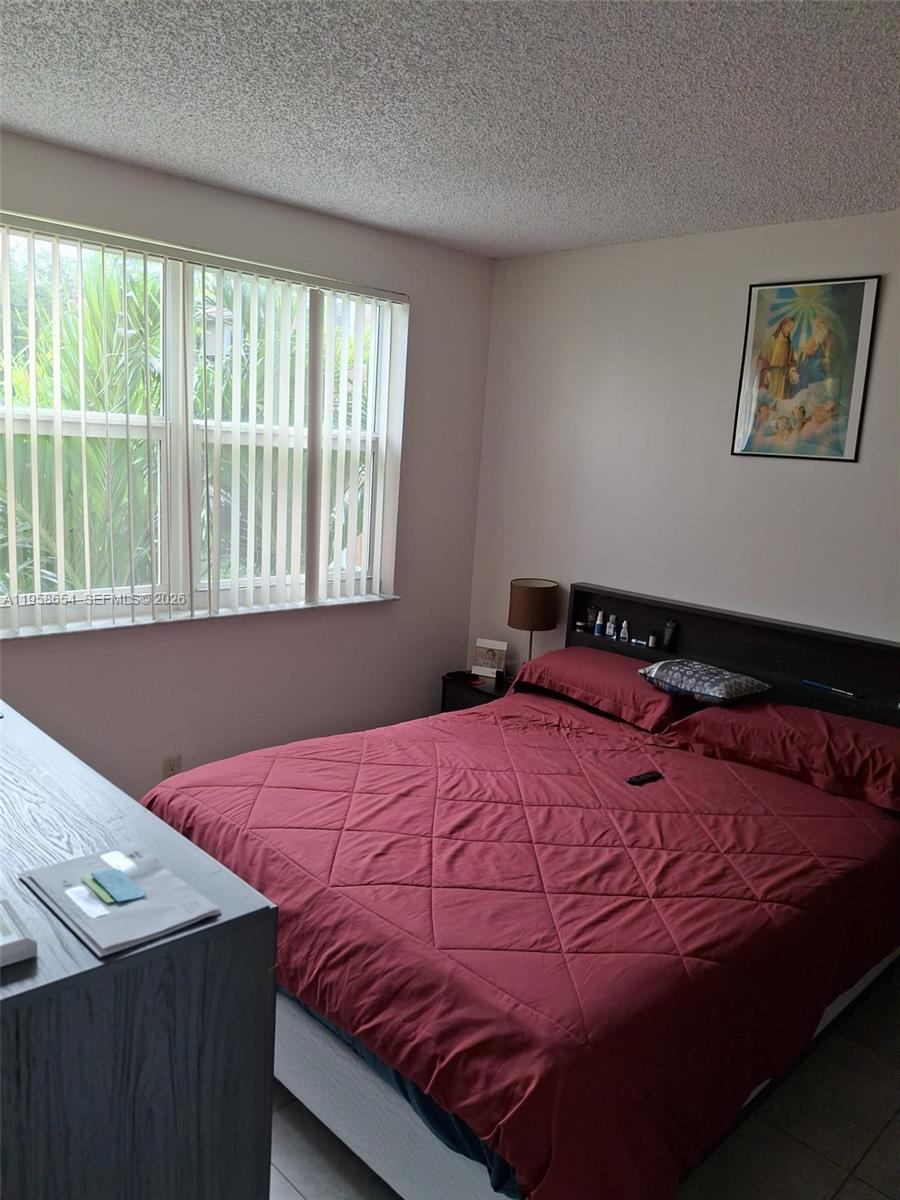 8801 Wiles Road, Unit 208 Coral Springs, FL 33067 - Photo 11 of 11 a bedroom with a bed and a window