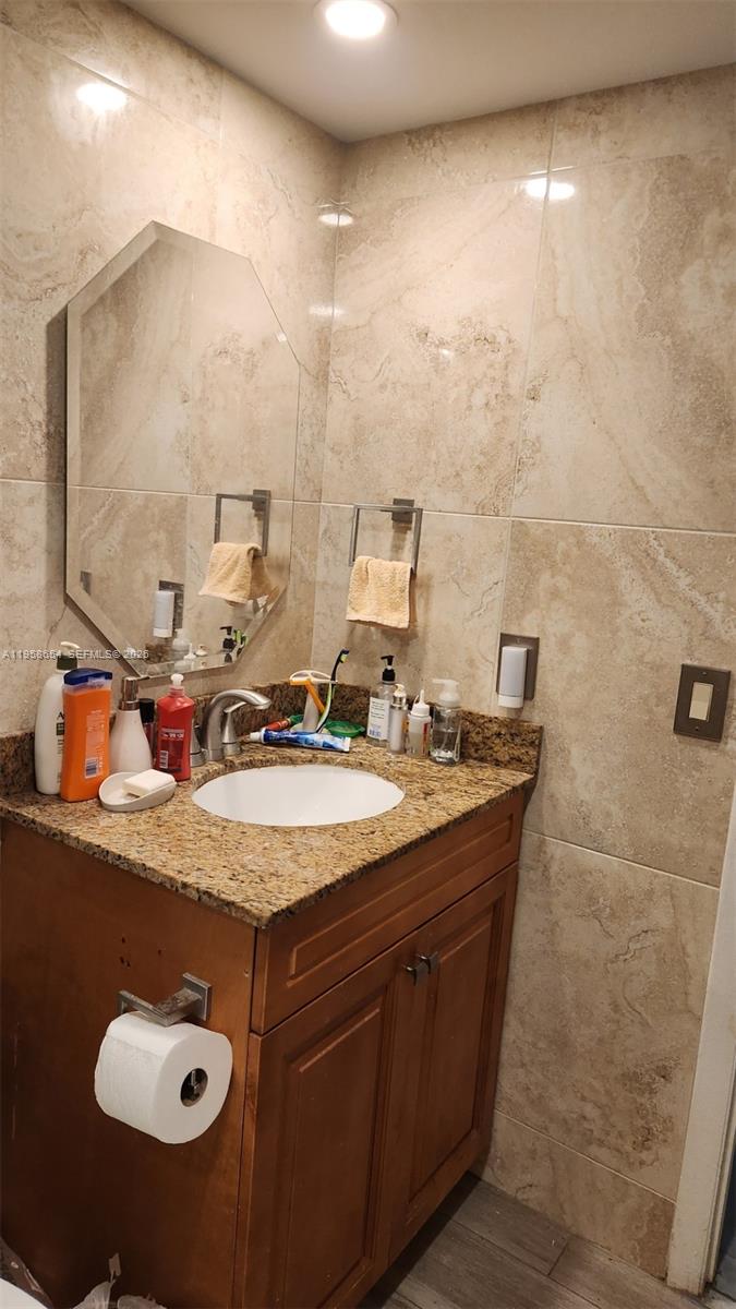 8801 Wiles Road, Unit 208 Coral Springs, FL 33067 - Photo 6 of 11 a bathroom with a granite countertop sink a mirror and shower