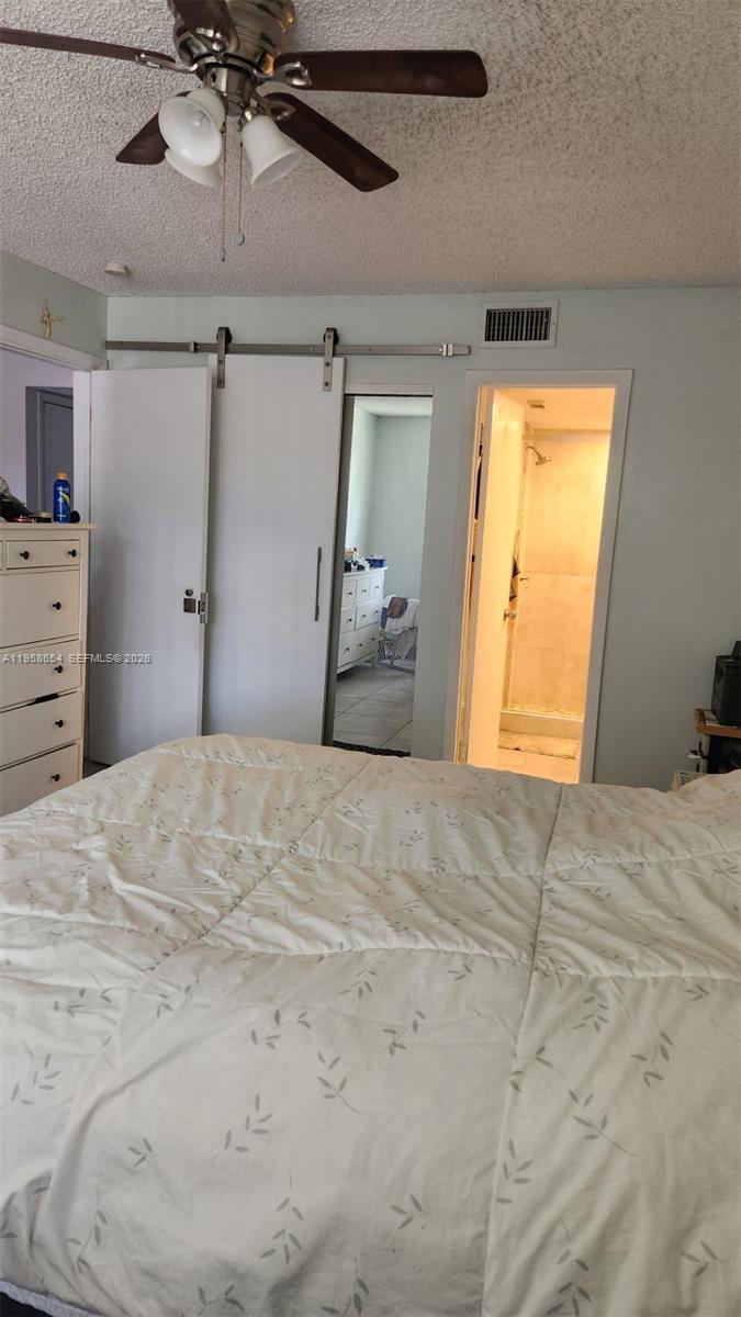 8801 Wiles Road, Unit 208 Coral Springs, FL 33067 - Photo 8 of 11 a bedroom with a bed and a chandelier