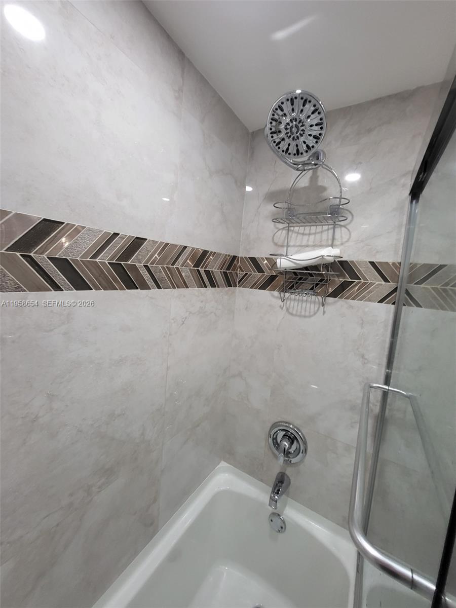 8801 Wiles Road, Unit 208 Coral Springs, FL 33067 - Photo 9 of 11 a bathroom with a bathtub and shower