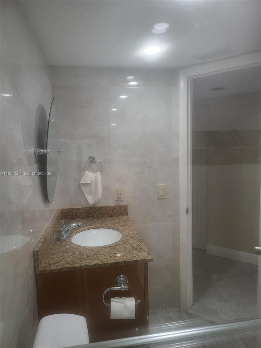 8801 Wiles Road, Unit 208 Coral Springs, FL 33067 - Photo 10 of 11 a bathroom with a sink and a toilet