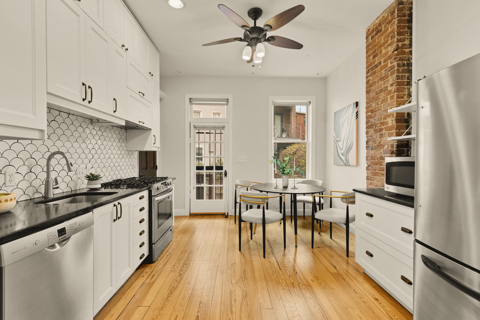 619 Independence Avenue Southeast Washington, DC 20003 - Photo 11 of 38 a kitchen with stainless steel appliances granite countertop a stove top oven a sink a dining table and chairs with wooden floor