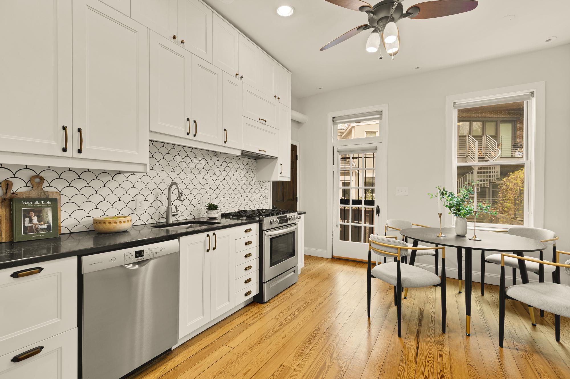 619 Independence Avenue Southeast Washington, DC 20003 - Photo 12 of 38 a kitchen with stainless steel appliances granite countertop a stove top oven a sink a dining table and chairs with wooden floor
