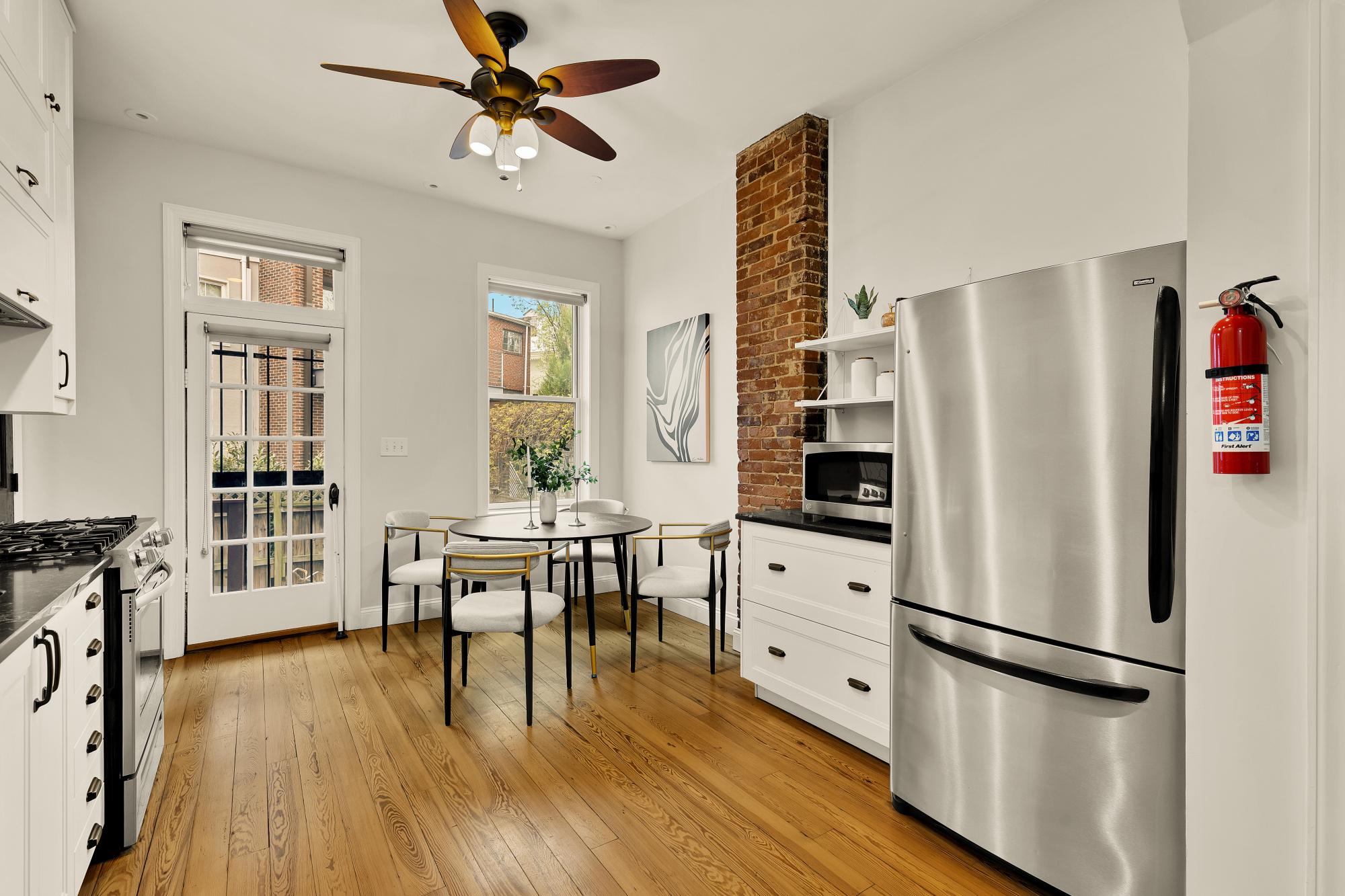 619 Independence Avenue Southeast Washington, DC 20003 - Photo 10 of 38 a kitchen with stainless steel appliances a refrigerator a stove a dining table and chairs with wooden floor