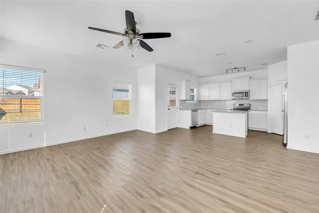 a view of a kitchen with a sink and dishwasher a refrigerator with wooden floor