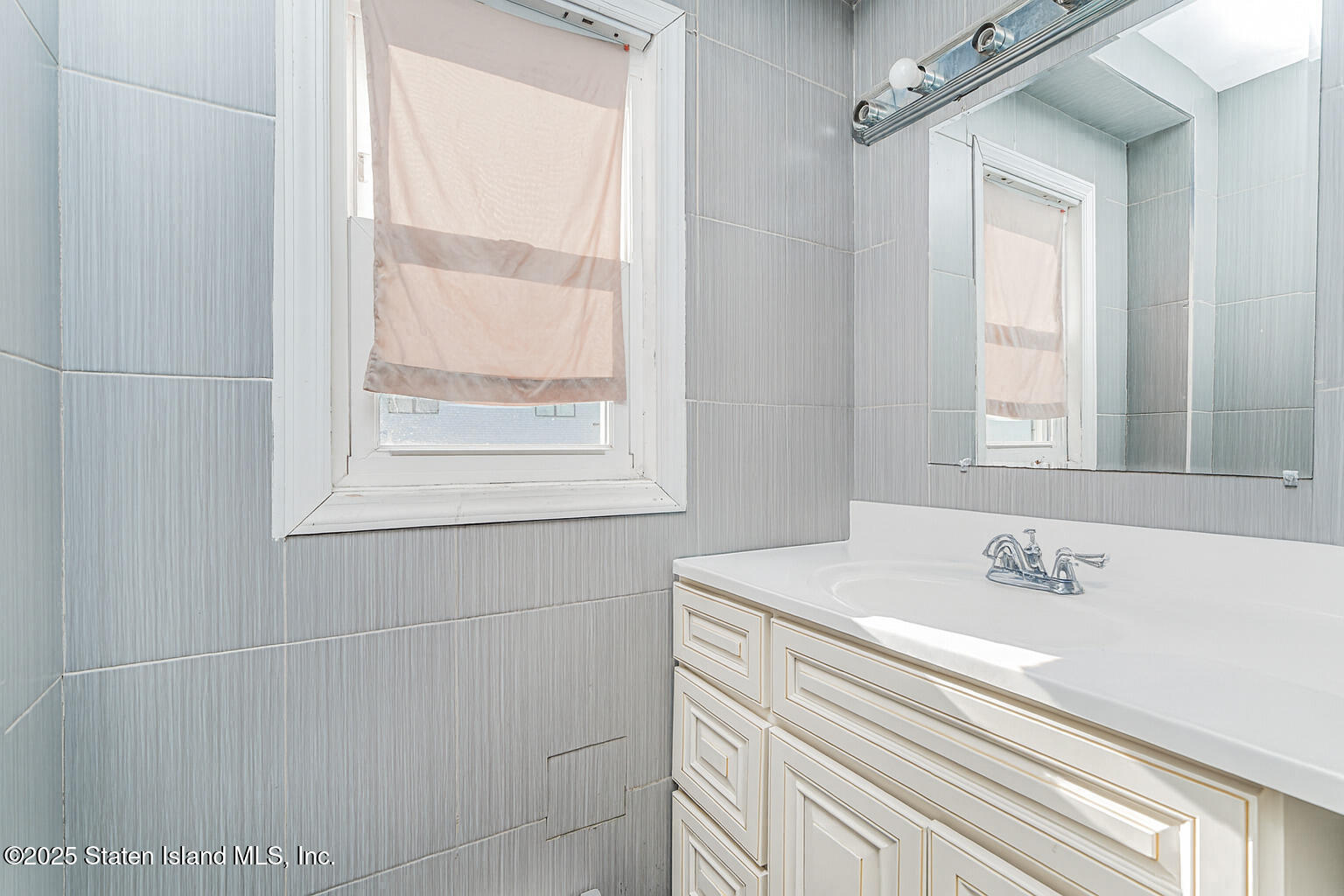 4062 Amboy Road Staten Island, NY 10308 - Photo 10 of 21 a bathroom with a sink a vanity and a window