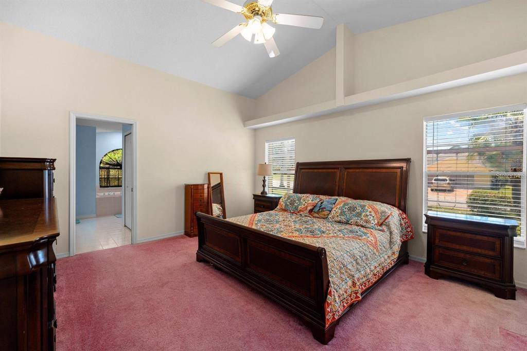 10228 Yellow Pine Way Hudson, FL 34667 - Photo 16 of 22 a bedroom with a bed window and a flat tv screen on a dresser