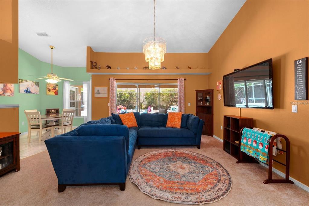 10228 Yellow Pine Way Hudson, FL 34667 - Photo 5 of 22 a living room with fireplace furniture and a chandelier