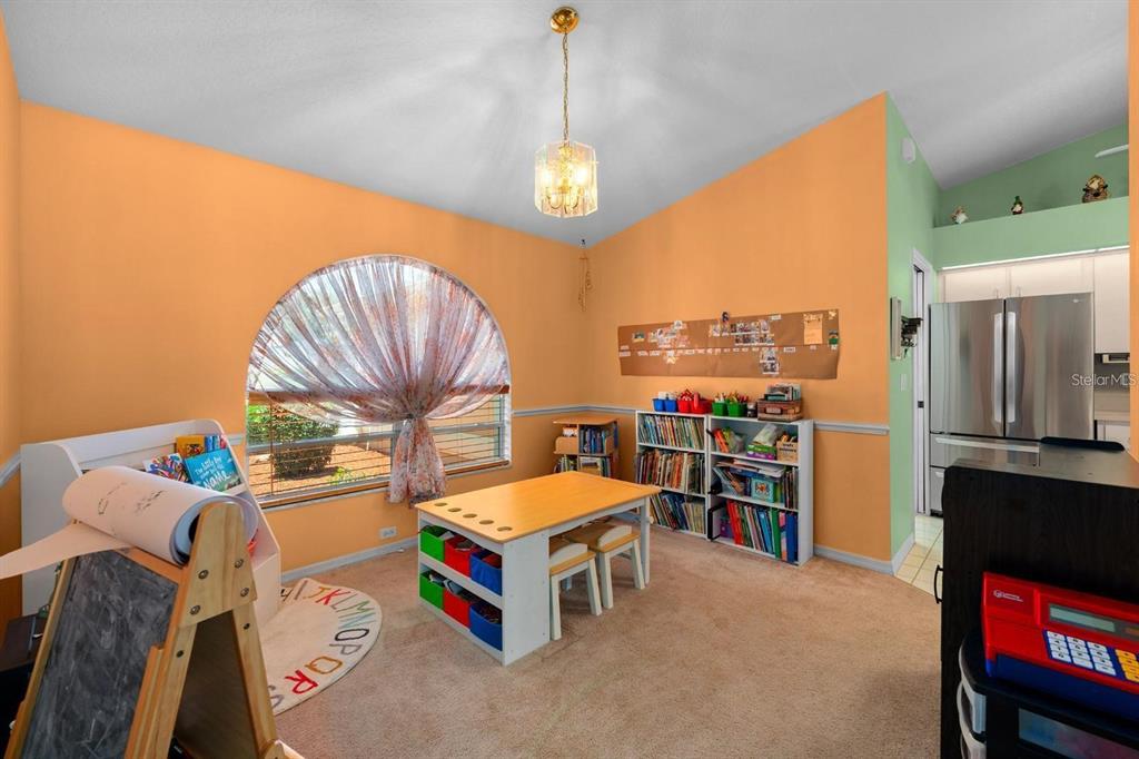 10228 Yellow Pine Way Hudson, FL 34667 - Photo 6 of 22 a living room with a bed furniture and a chandelier