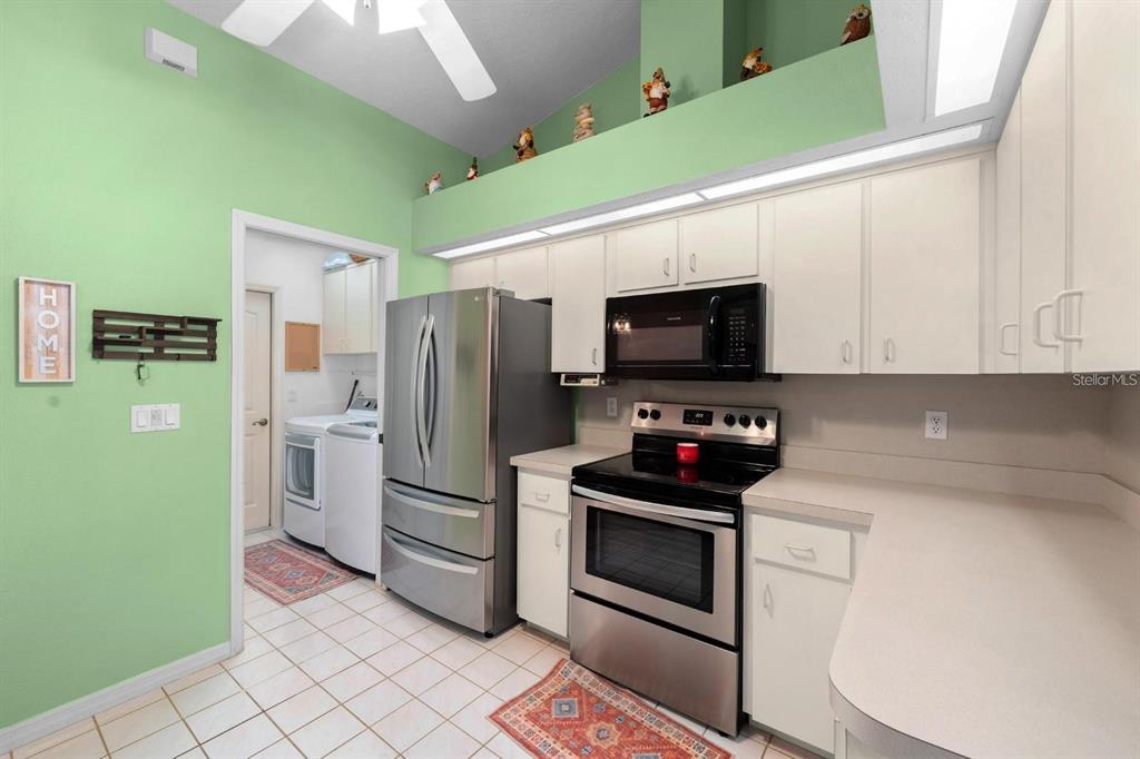 10228 Yellow Pine Way Hudson, FL 34667 - Photo 8 of 22 a kitchen with a refrigerator and a stove top oven