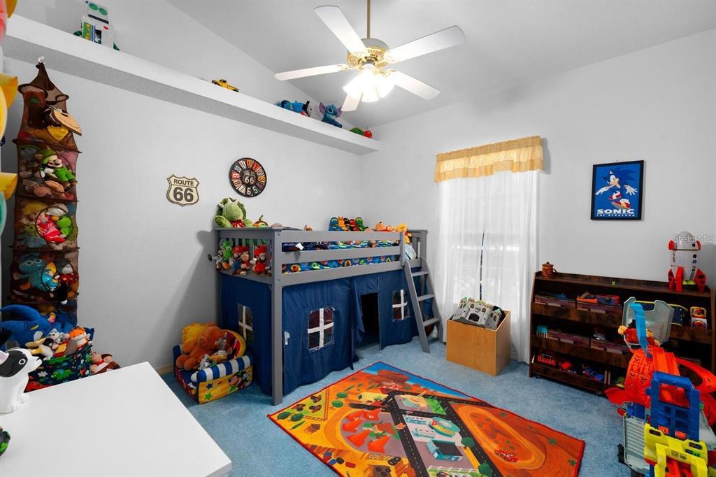 10228 Yellow Pine Way Hudson, FL 34667 - Photo 10 of 22 a bed room with furniture a baby crib and a couch