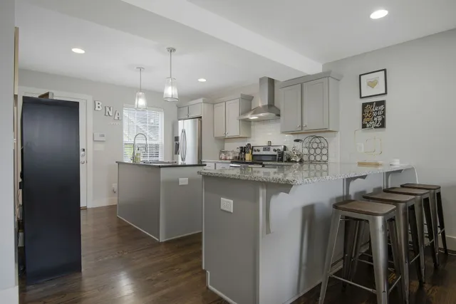 a kitchen with stainless steel appliances granite countertop a sink a stove and a refrigerator