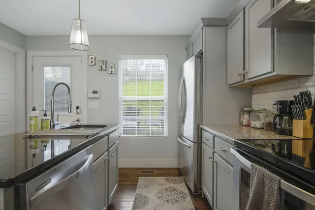 a kitchen with stainless steel appliances granite countertop a sink and stove top oven