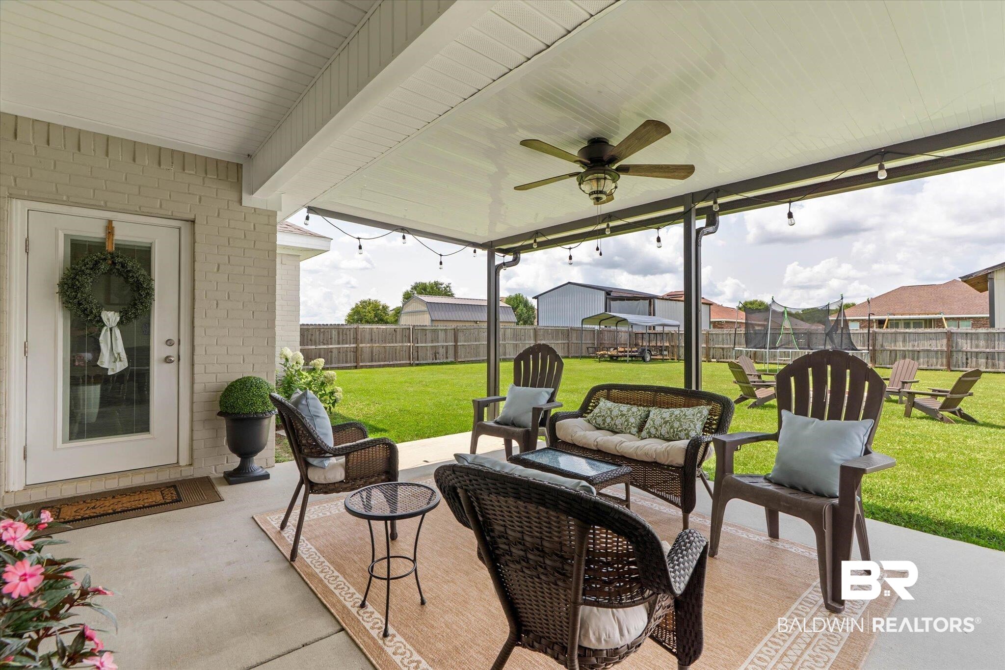 9074 Moses Way Theodore, AL 36582 - Photo 42 of 52 Expansive covered patio featuring a ceiling fan, string lighting, and a view of the fenced backyard